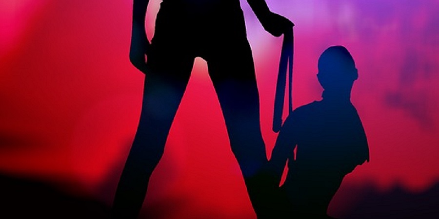 Zwei dunkle Figuren mit rotem Hintergrund beim BDSM Spiel