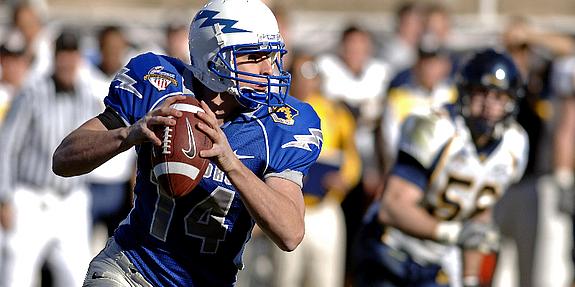 Footballer in blauem Trikot schießt Ball