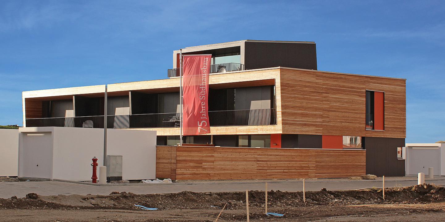 Passivhaus in modernen Architektenstil mit Holz und Glas vor blauem Himmel