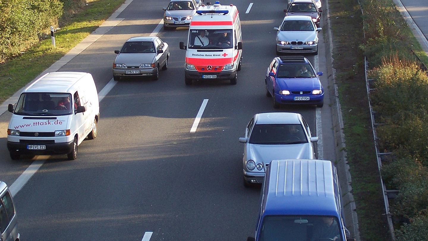 Bild von Autos auf Autobahn, die ordnungsgemäß eine Rettungsgasse bilden und so einem Einsatzwagen die Durchfahrt ermöglichen.