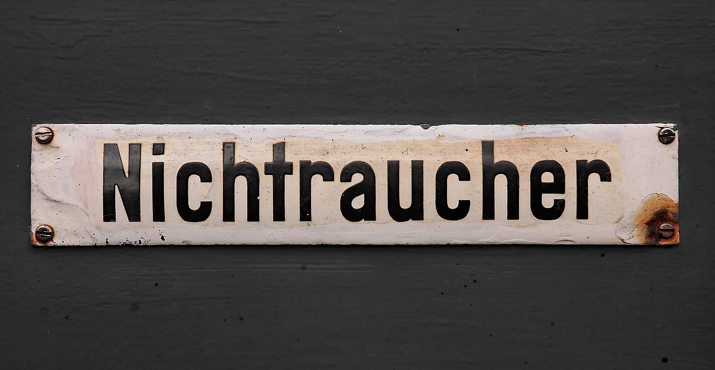 Altes Nichtraucher-Schild vor grauem Hintergrund