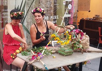 zwei Frauen binden Blumengränze