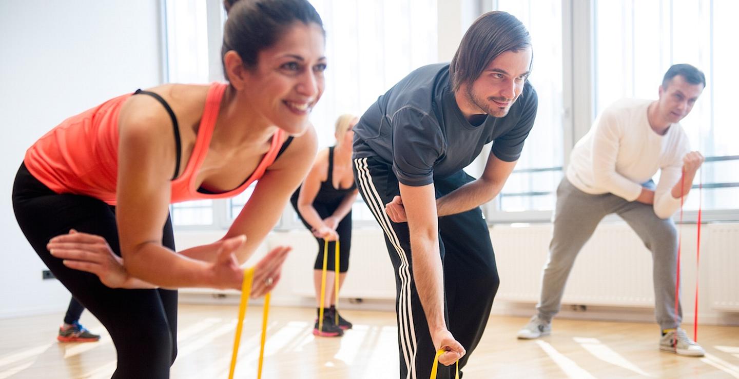 Drei Menschen machen Gymnastik