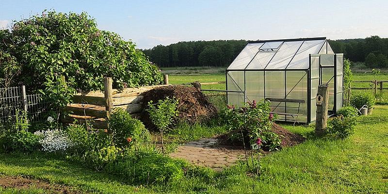 kleines Grünhaus in einem Garten auf einem Feld