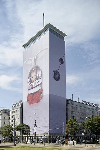 Der verhüllte Ringturm. Zu sehen ist ein Baby verkleidet als Astronaut. 