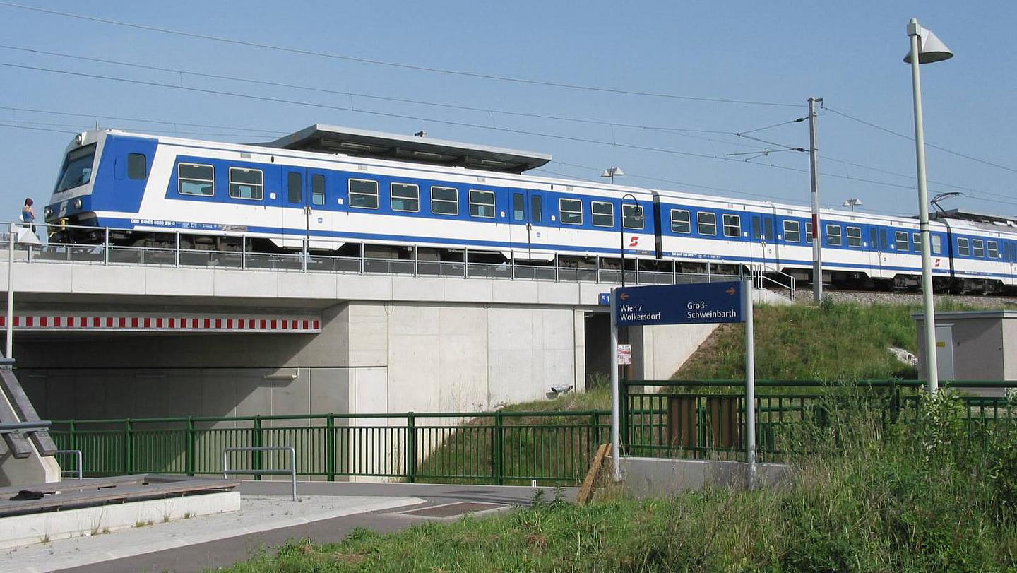 Bild von S-Bahn-Linie 2, über eine Brücke fährt. Der Zug befindet sich in Obersdorf und geht in Richtung Wolkersdorf.