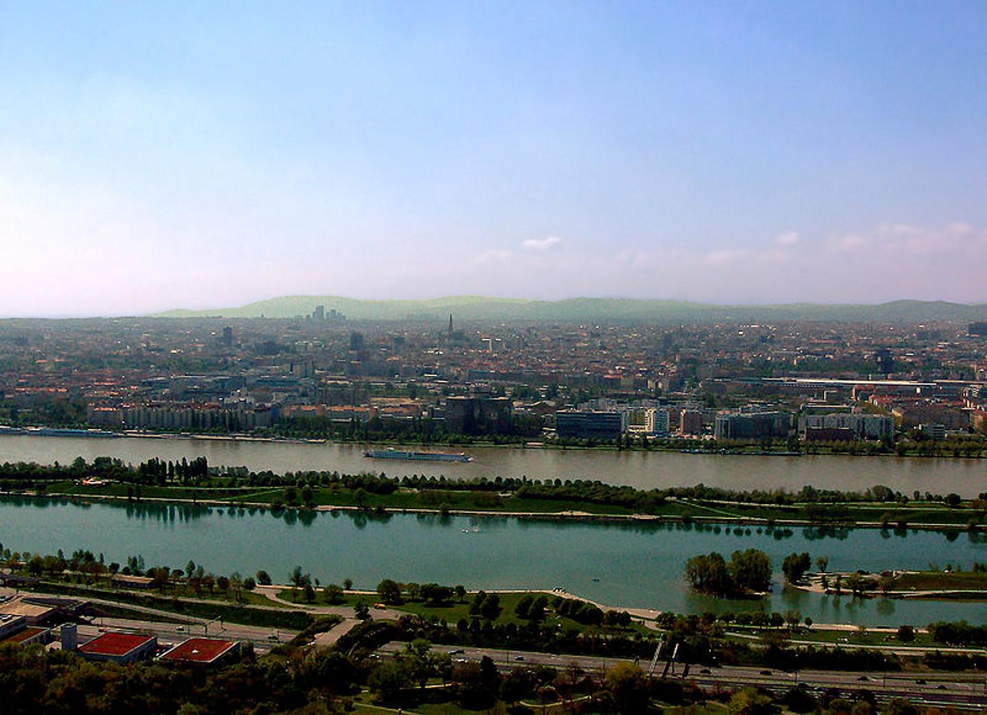 Weitwinkel auf die Donau, mit der Neuen Donau, Donauinsel, Wien Skyline und im Hintergrund den Wienerwald.