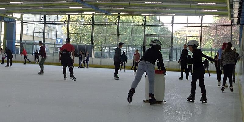 Kinder fahren mit Helm auf einer Eisfläche