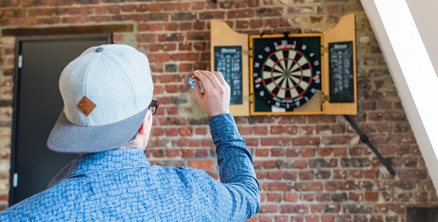 Mann spielt Darts