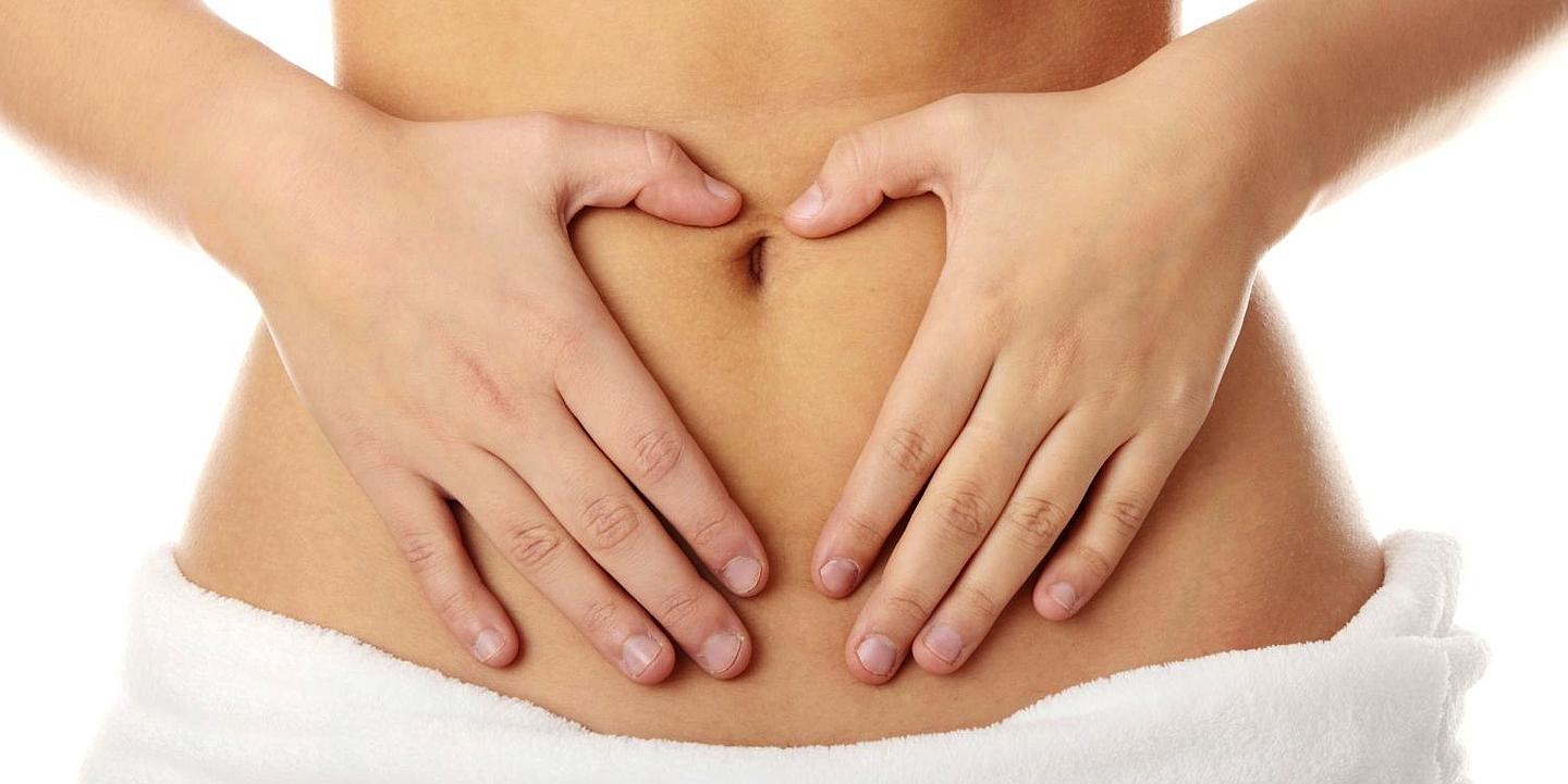 Frau, deren Hände auf ihrem Bauch liegen 