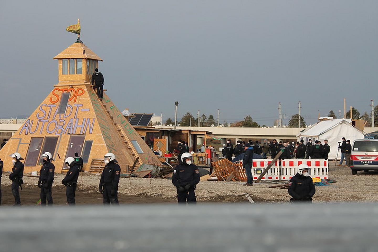 Polizei formiert sich vor Holz-Pyramide auf dem Protestcamp gegen die Lobau-Autobahn