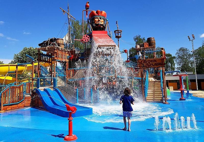 Mädchen steht vor Wasserrutsche