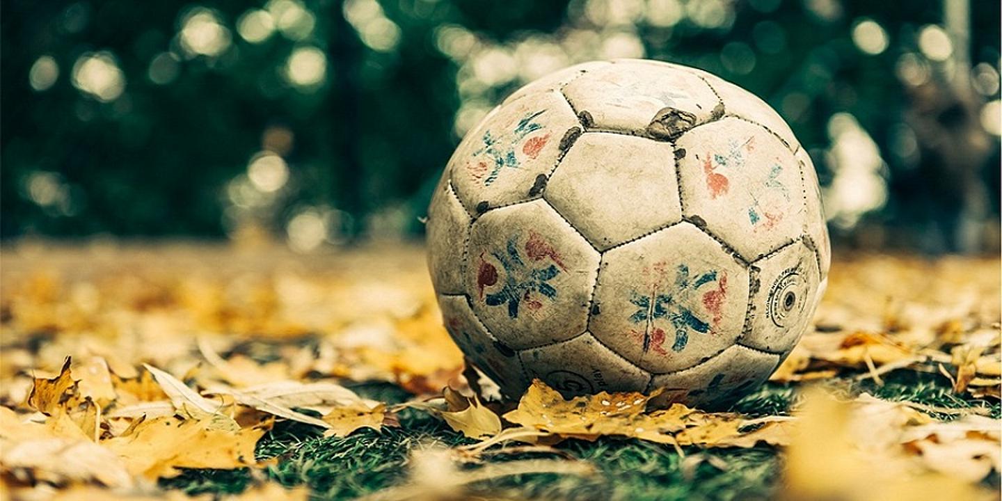 ein alter Ball der auf vergilbten Blättern liegt