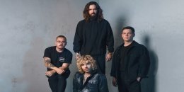 Die Band Tokio Hotel, alle Mitglieder vor grauem Hintergrund.