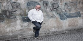 Musiker Konstantin Wecker vor einer Wand mit Graffiti