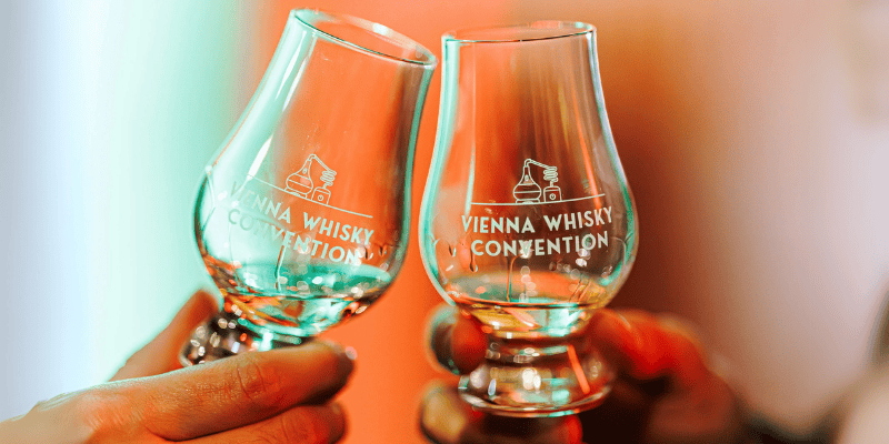 Zwei Personen stoßen mit Whiskygläsern beim Vienna Whisky Festival an