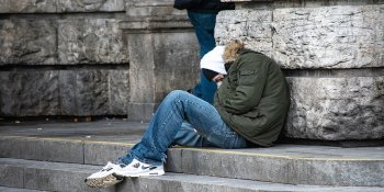 frierender Obdachloser sitzt auf Treppe