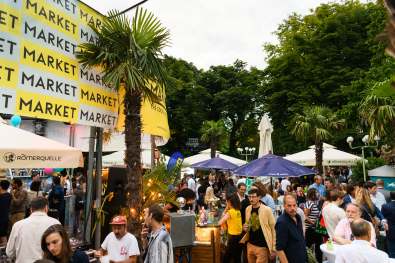 Liquid Market Logo im Hintergrund, Gäste tummeln sich auf dem Festival