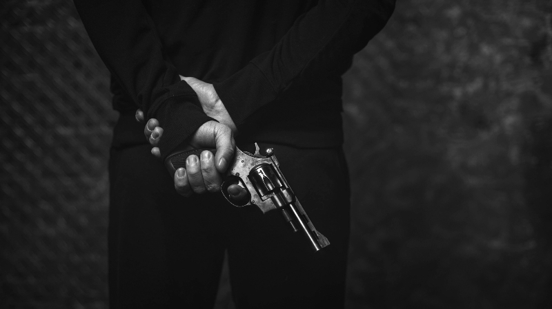 James Bond mit Rücken zur Kamera, hält eine Pistole in der Hand