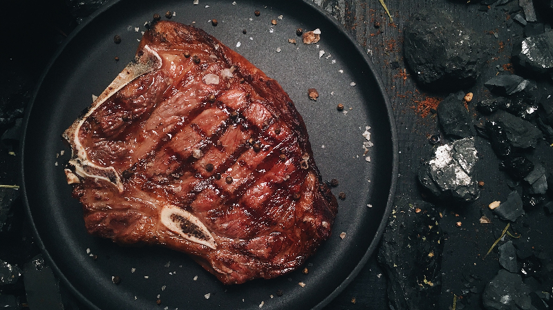 Gut gebratenes Steak auf einem schwarzen Teller